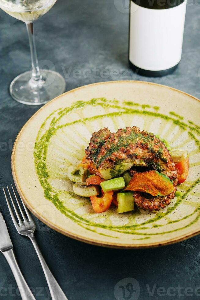 delicious octopus dish with roasted mushrooms, zucchini and peppers photo