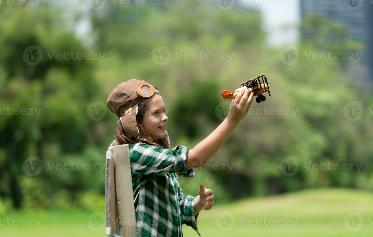 A little girl on vacation at the park with a pilot outfit and flying equipment. Run around and have fun with her dreams. photo