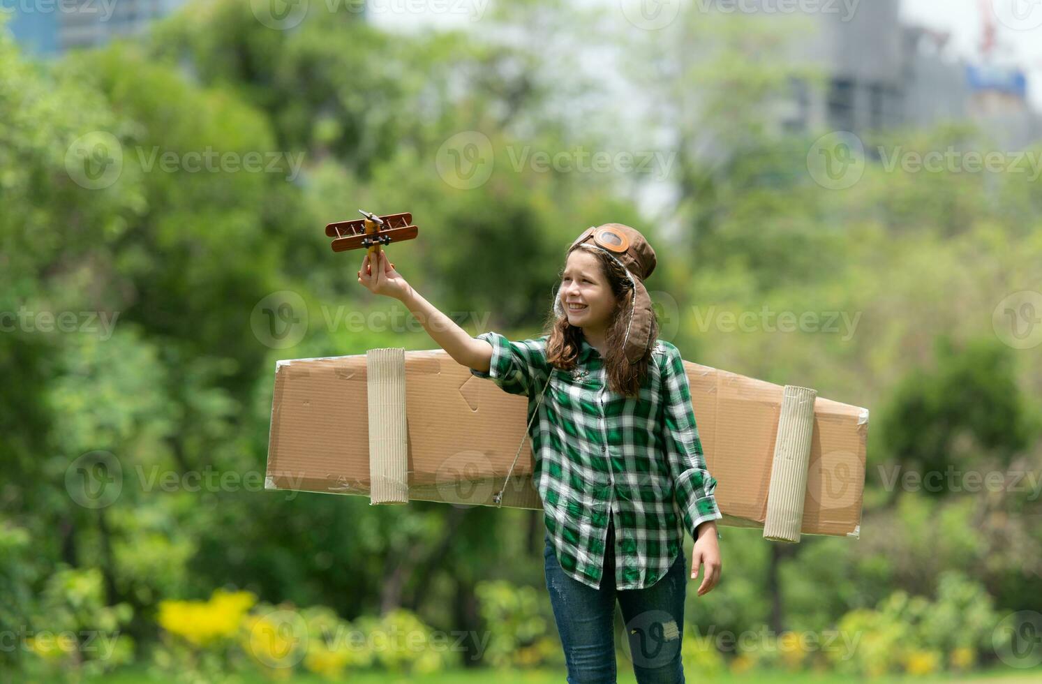 A little girl on vacation at the park with a pilot outfit and flying equipment. Run around and have fun with her dreams. photo