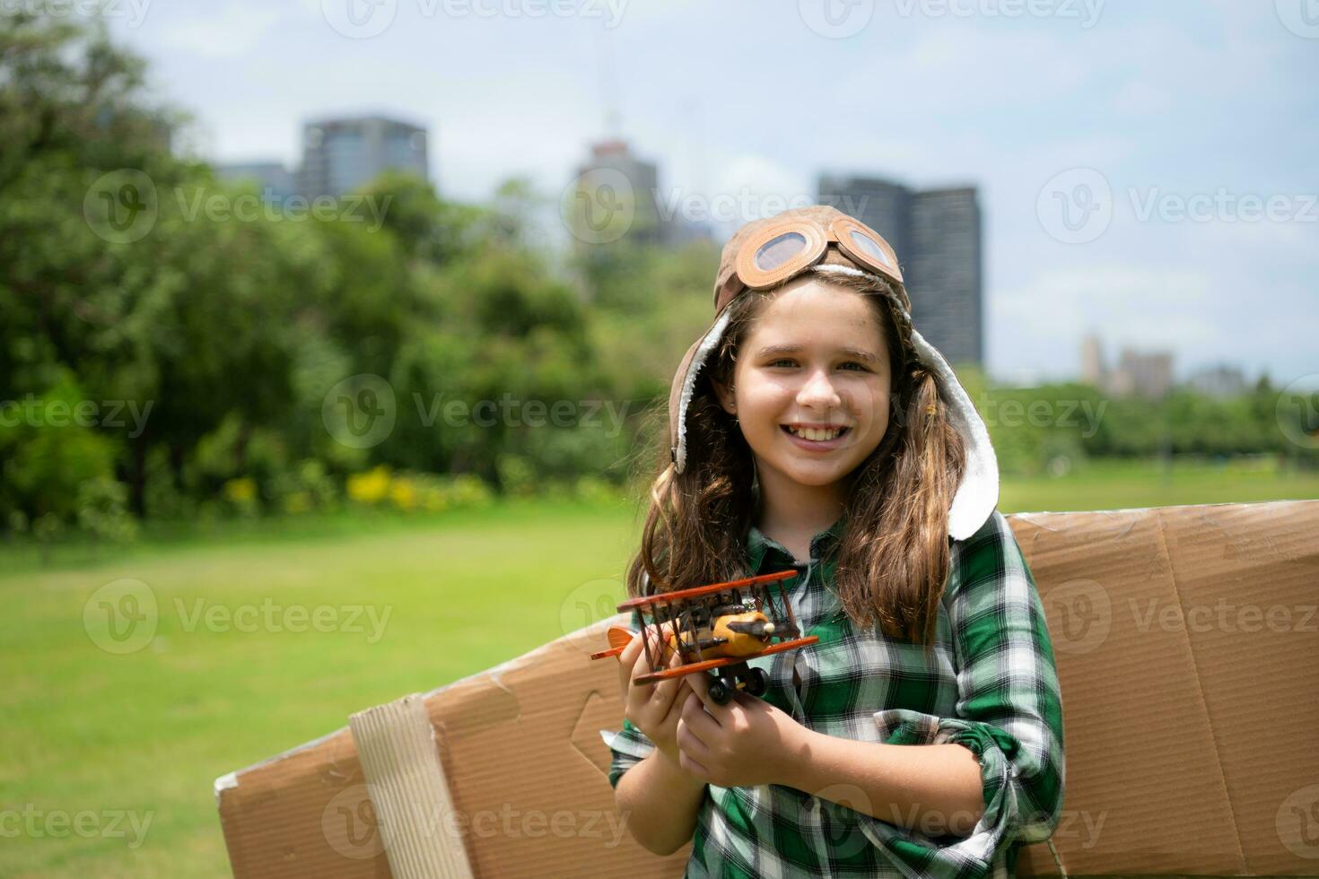 un pequeño niña en vacaciones a el parque con un piloto atuendo y volador equipo. correr alrededor y tener divertido con su Sueños. foto
