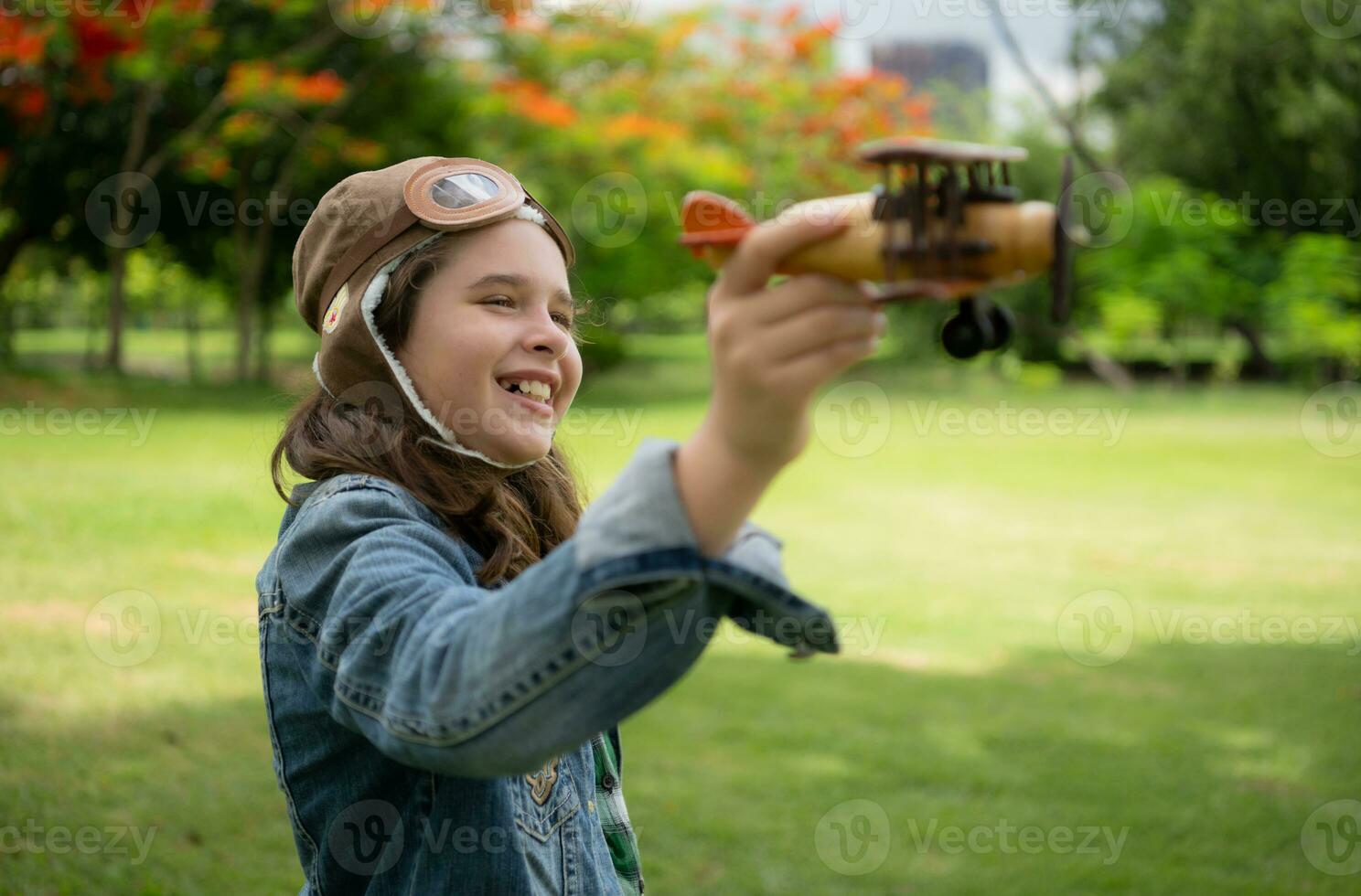 un pequeño niña en vacaciones a el parque con un piloto atuendo y volador equipo. correr alrededor y tener divertido con su Sueños. foto