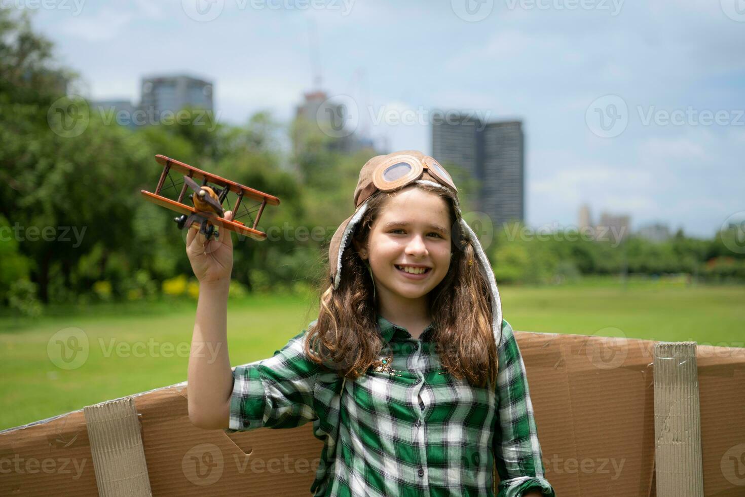 A little girl on vacation at the park with a pilot outfit and flying equipment. Run around and have fun with her dreams. photo