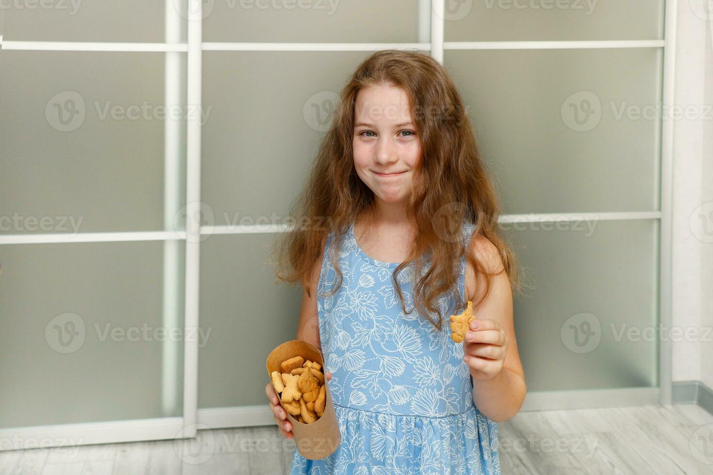 pequeño linda niña comiendo galletas foto