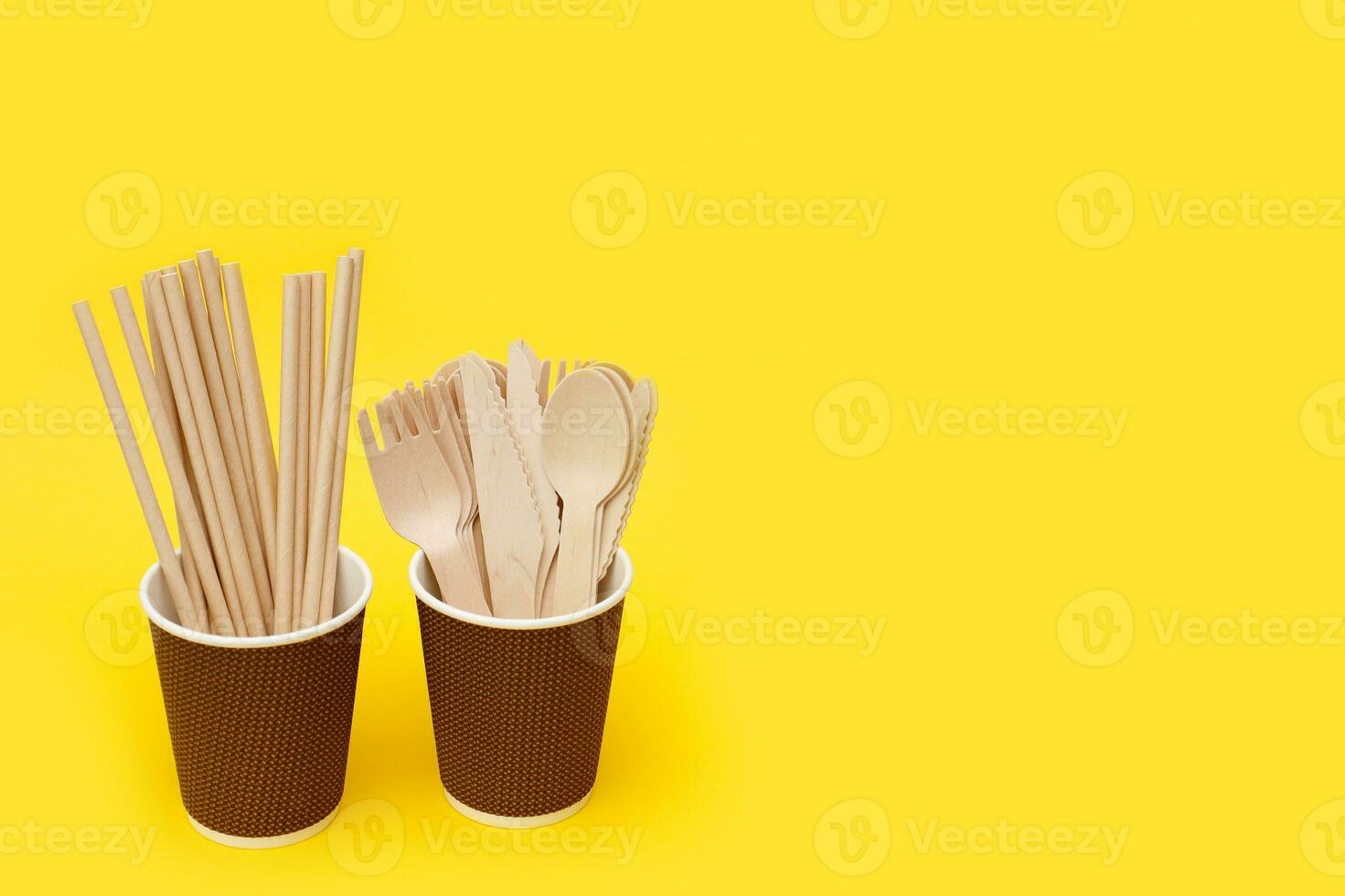 wooden disposable cutlery and paper tubes for a cocktail in paper cups with copy space photo