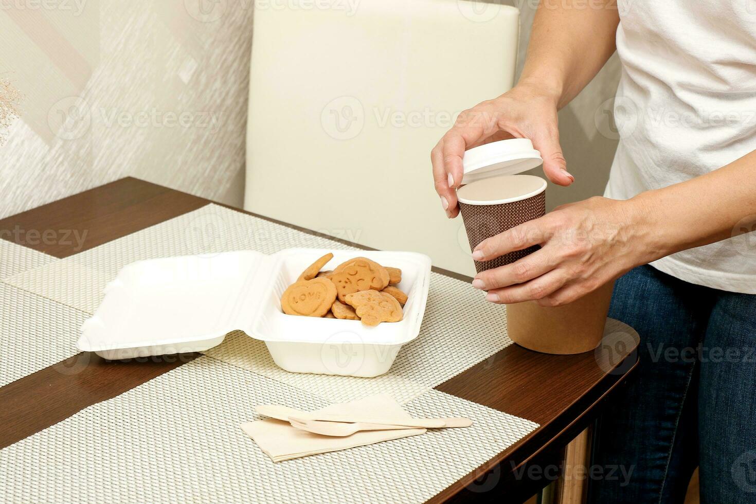 woman stacks food for child in lunchbox, cup and container photo