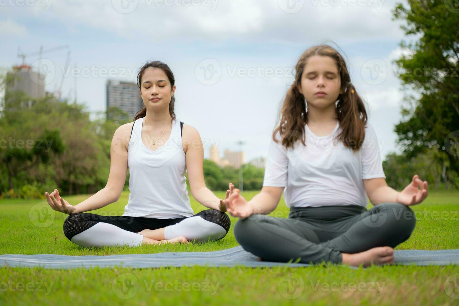 joven hembra y pequeño niña con al aire libre ocupaciones en el ciudad parque, yoga es su elegido actividad. foto