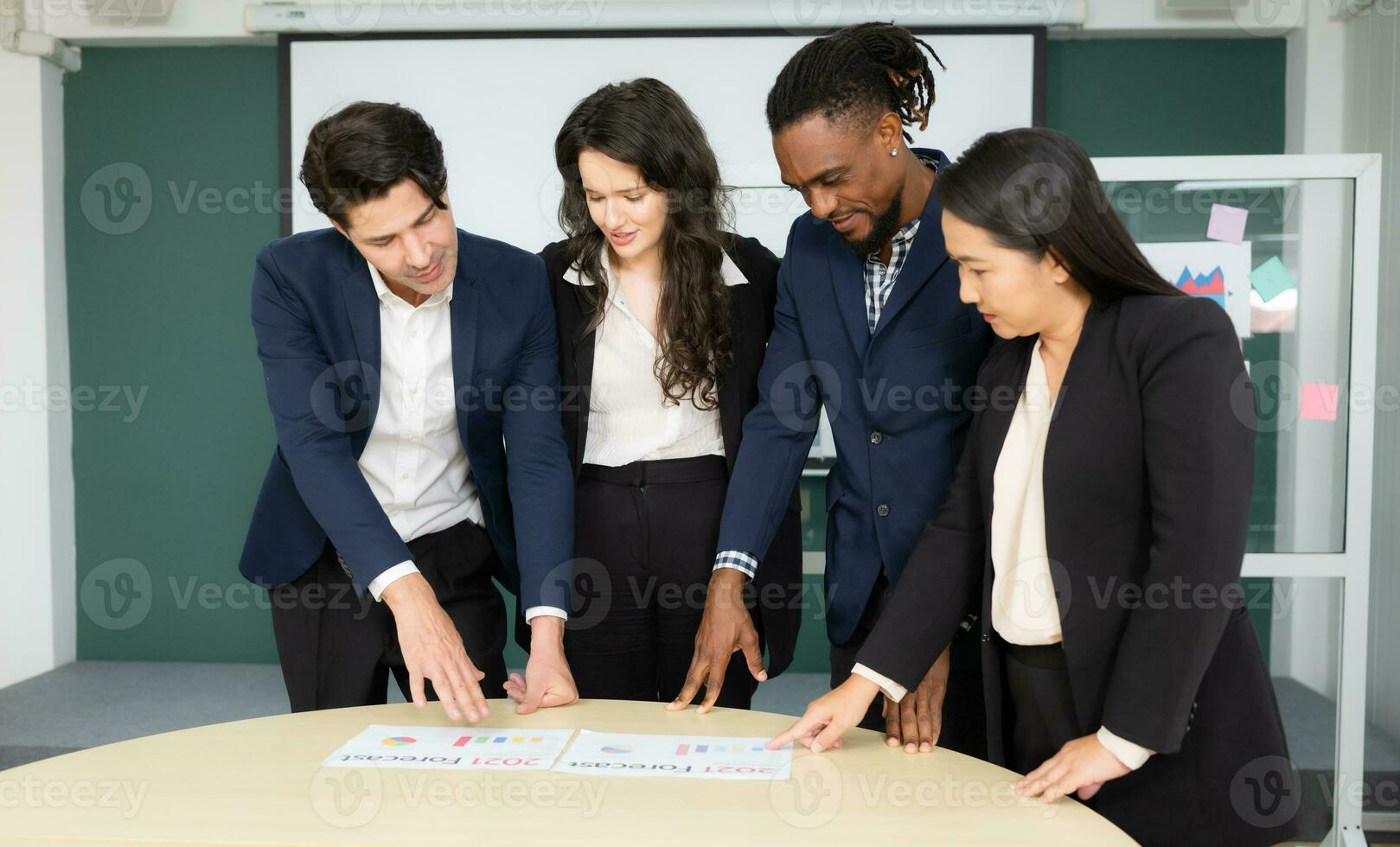 Group of business people discussing the charts and graphs showing the results of their successful teamwork photo