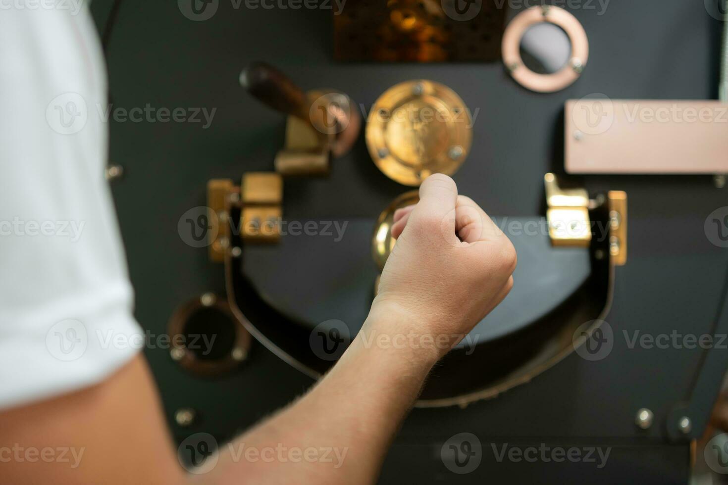 Portrait of a young man working with a coffee roaster machine photo