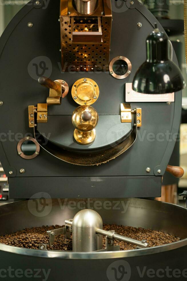 Coffee roaster machine with roasted coffee beans, close up photo