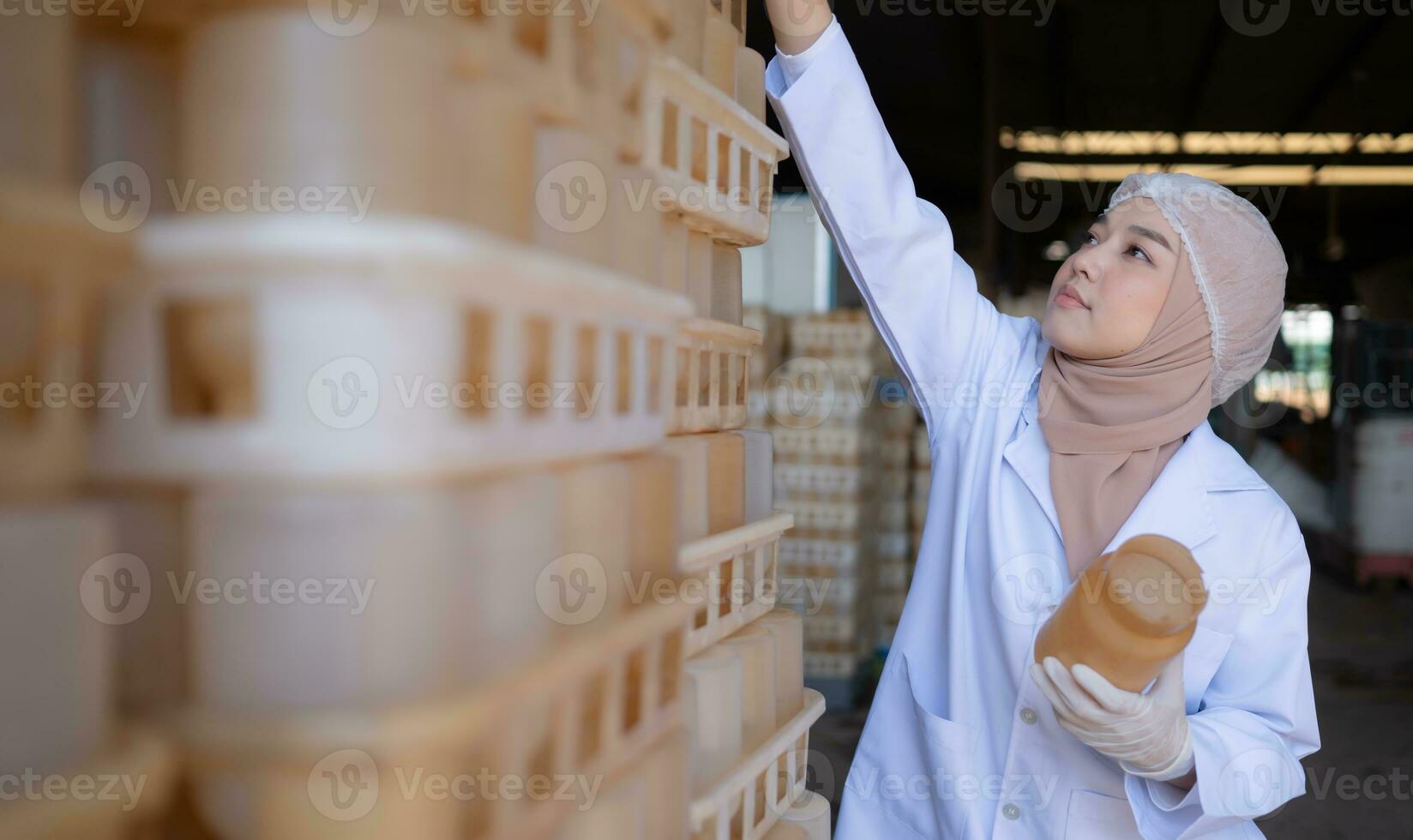 Portrait of a young scientist working in a laboratory She is examining the mushroom culture bottles in the mushroom house. photo