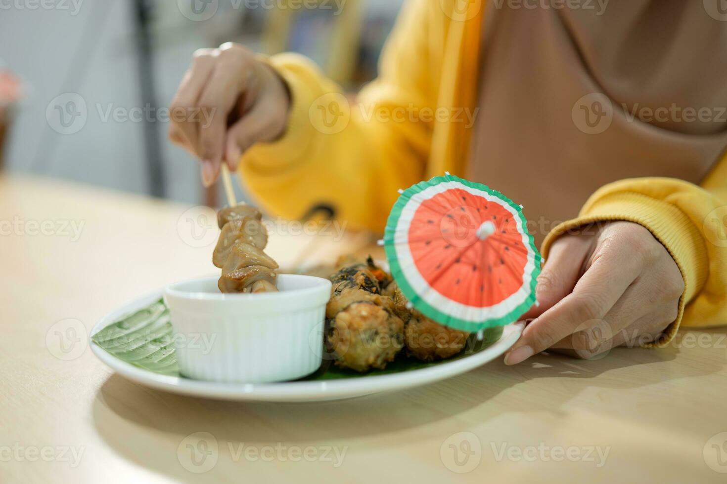 Muslim girl eating mushroom sushi at the restaurant. Selective focus on sushi photo