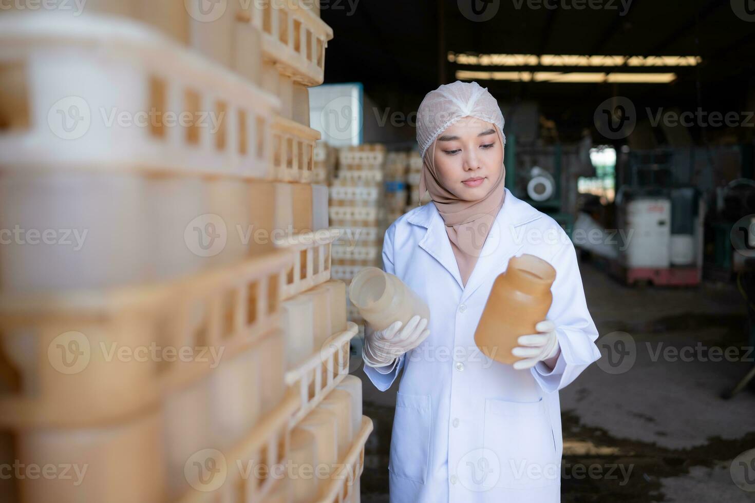 Portrait of a young scientist working in a laboratory She is examining the mushroom culture bottles in the mushroom house. photo
