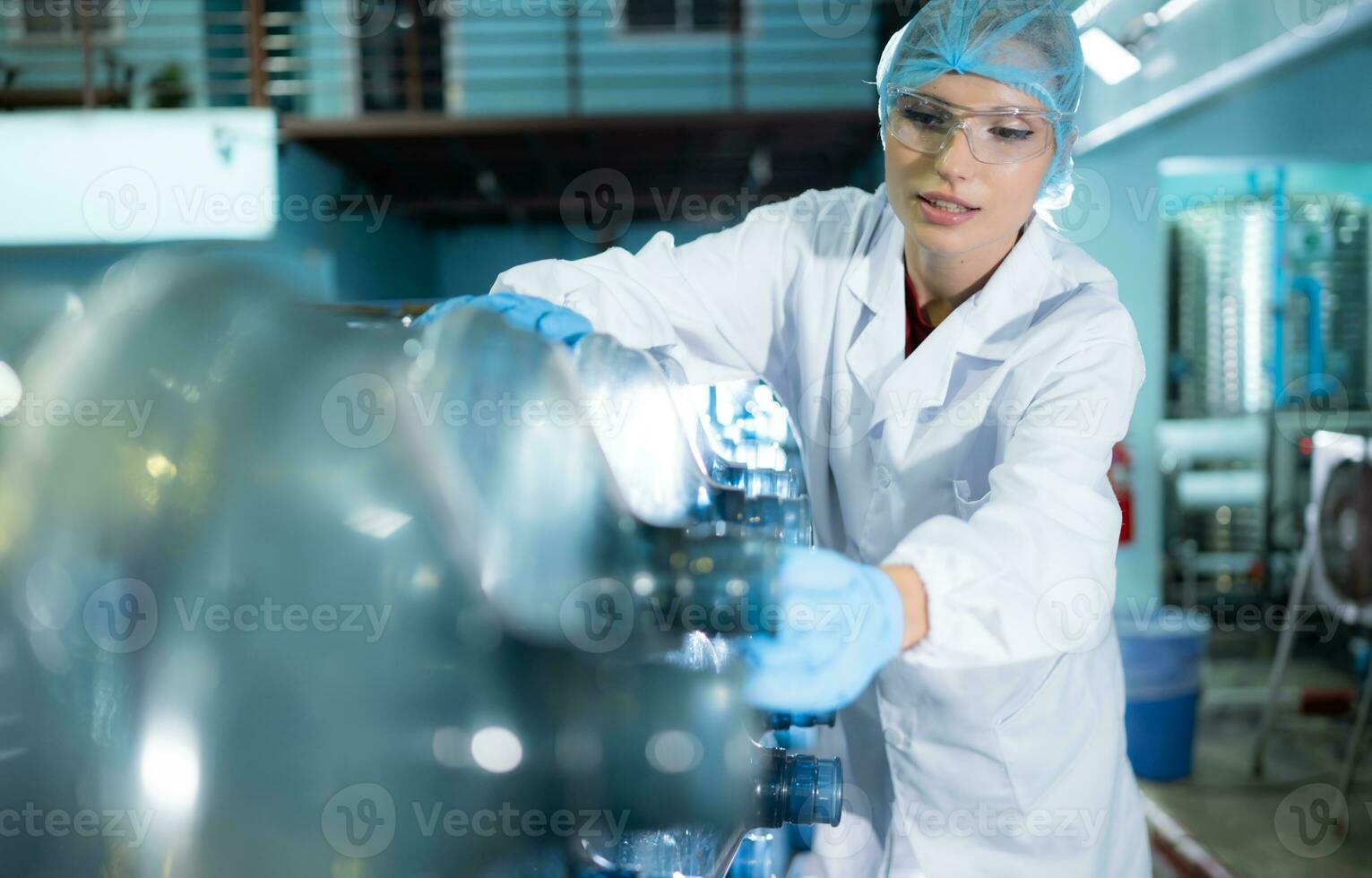 Female researcher carrying out scientific research in drinking water factory photo