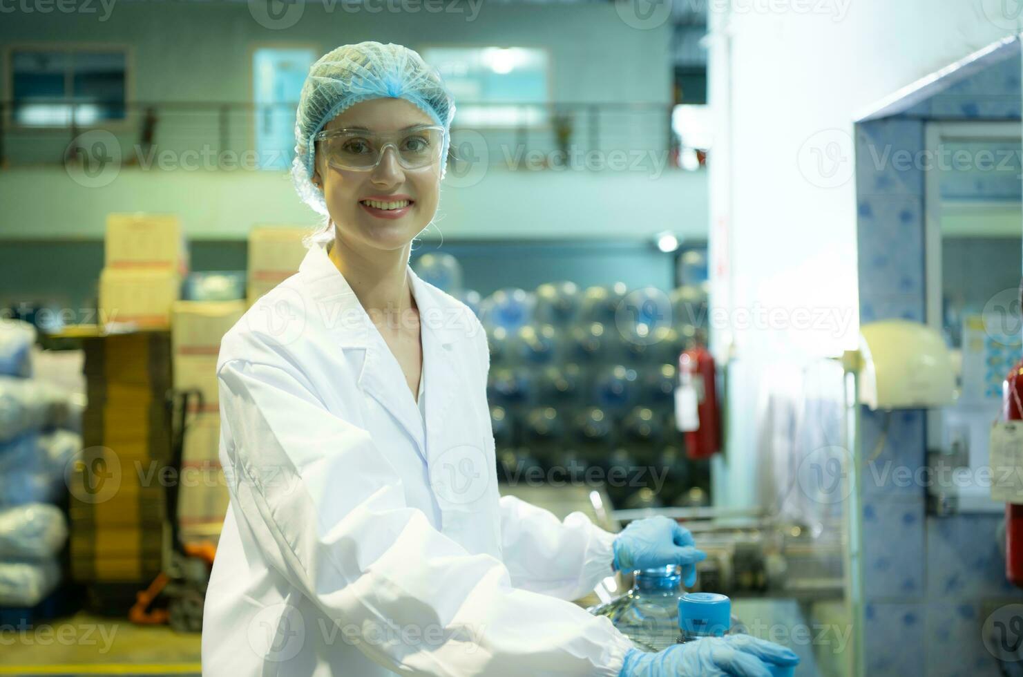 hembra calidad controlar trabajadores en un Bebiendo agua fábrica inspeccionando el calidad de agua tanques antes de importador el Bebiendo agua cinturón dentro el tanque foto