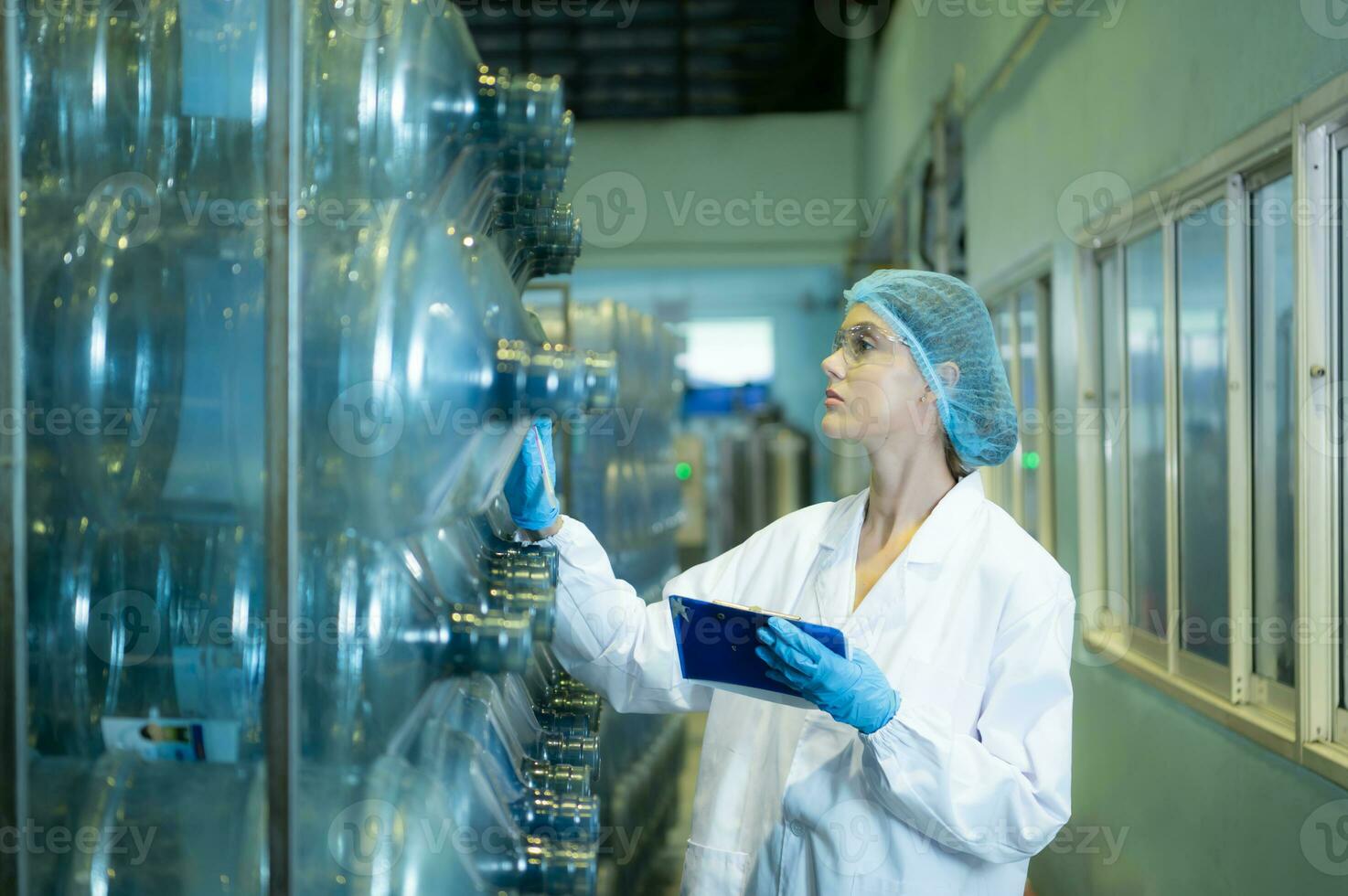 Female researcher carrying out scientific research in drinking water factory photo