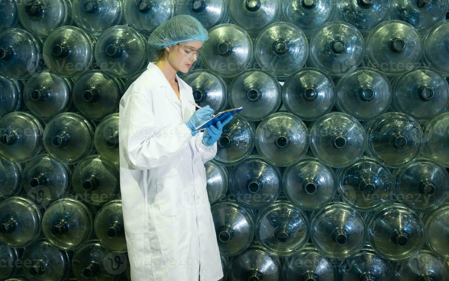 Female researcher carrying out scientific research in drinking water factory photo