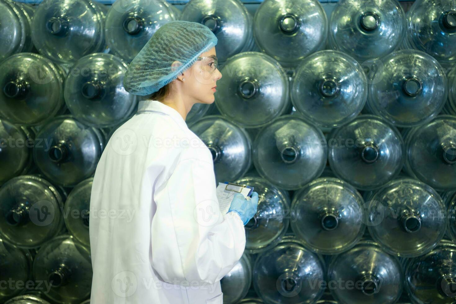 Female researcher carrying out scientific research in drinking water factory photo