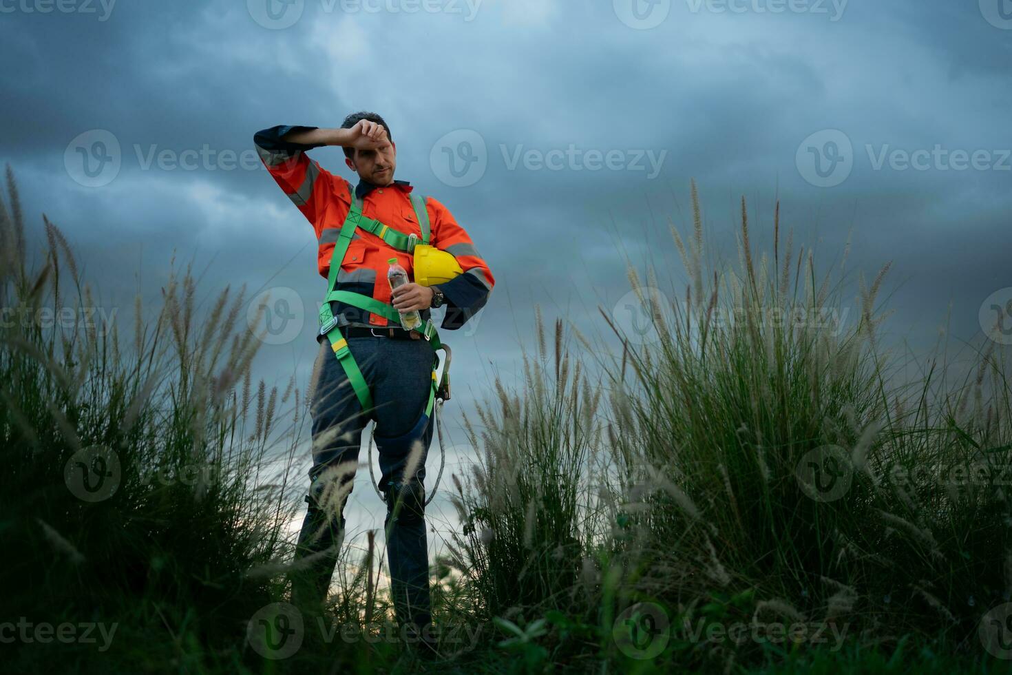 Portrait of a young man working in wind turbine field, wearing a safety vest, The concept of relax time after work photo