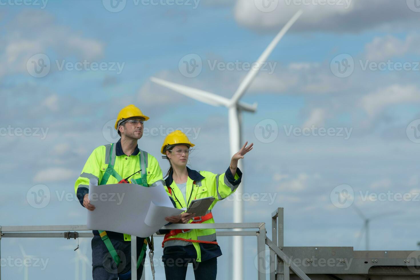 Engineer and technician discussing a solution problem of wind turbine before go in and check wind turbine, The concept of natural energy from wind. photo