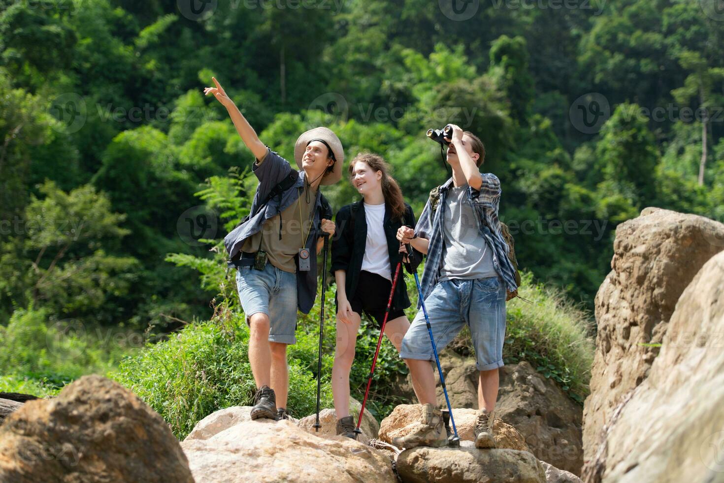 Group of tourists with backpacks walking on the trail in the river and mountains photo