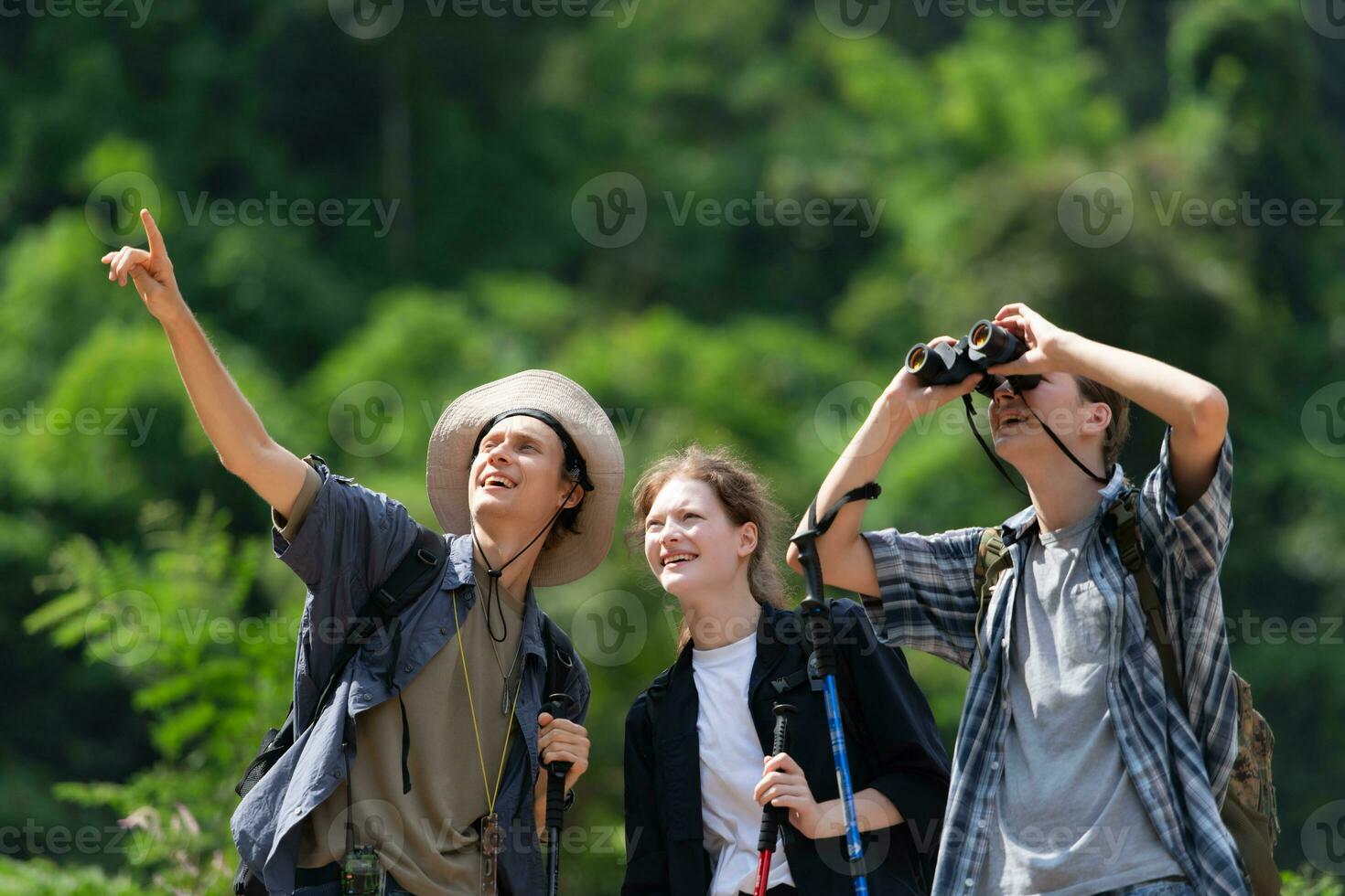 Group of tourists with backpacks walking on the trail in the river and mountains photo