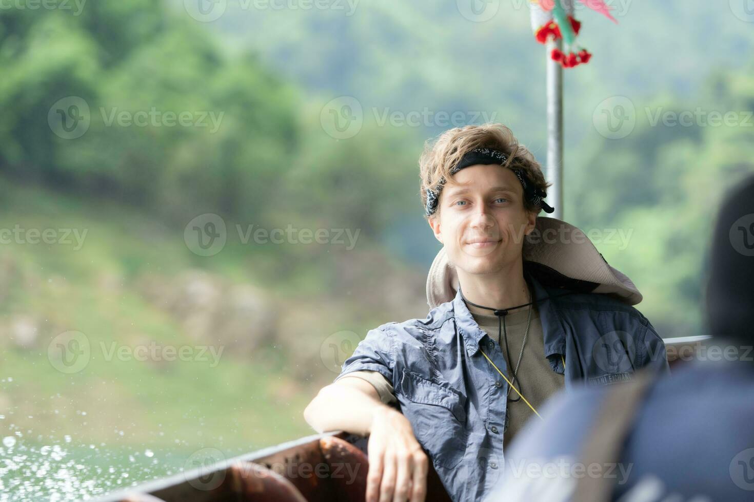 un joven hombre se sienta en un barco para un viaje dentro el bosque encima el represa para trekking foto