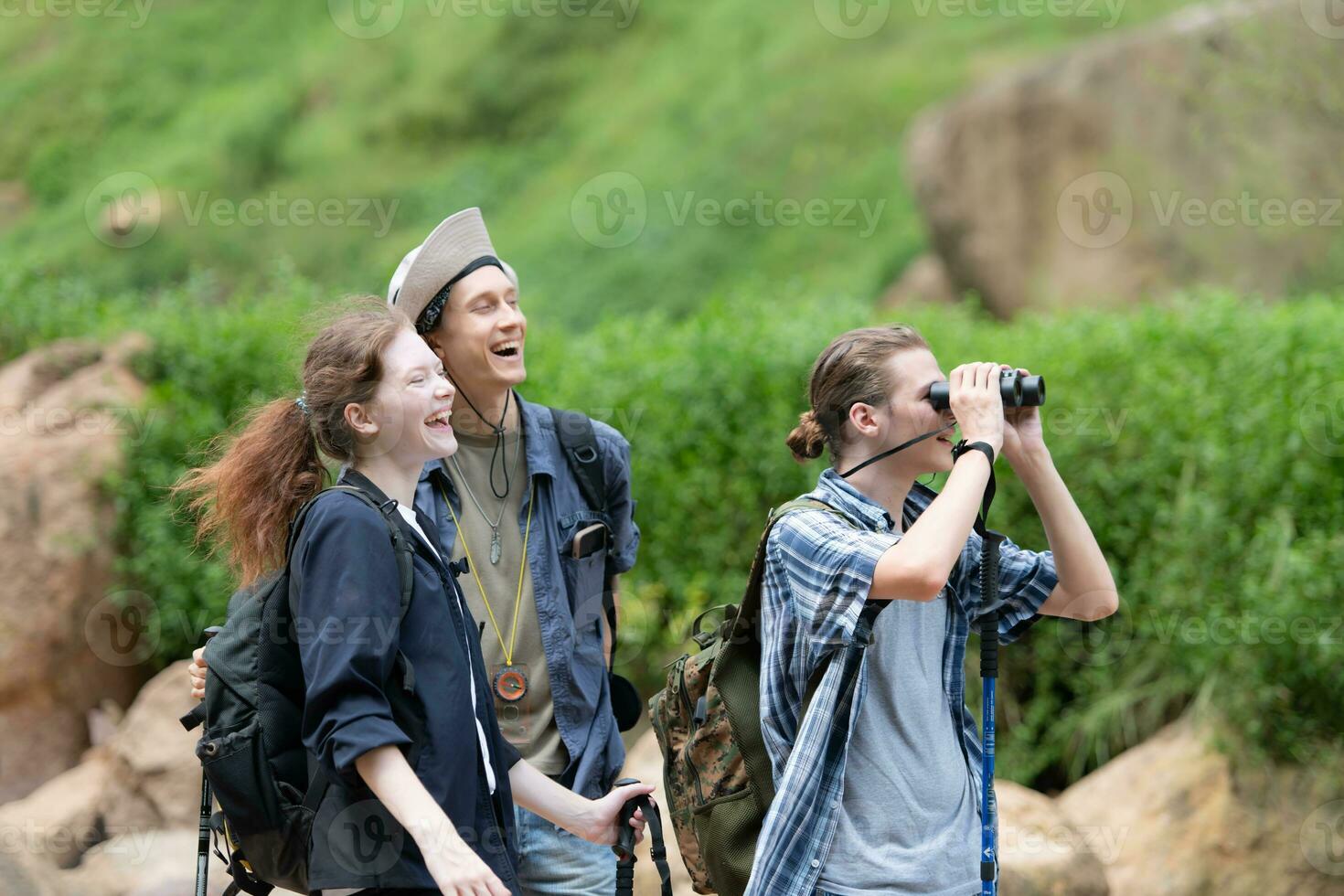 Group of tourists with backpacks walking on the trail in the river and mountains photo