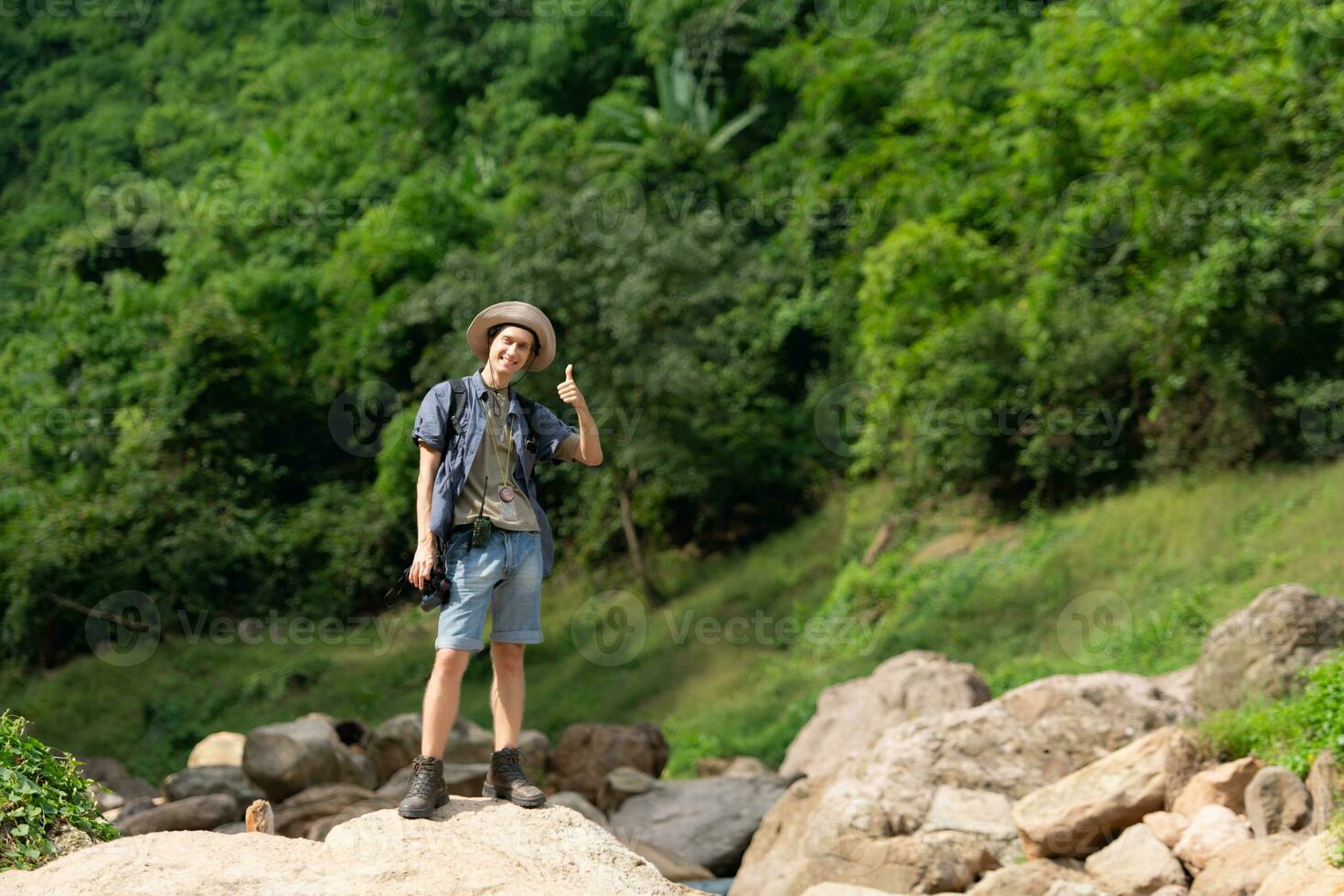 Young man with backpack hiking in the forest. Active lifestyle concept. photo