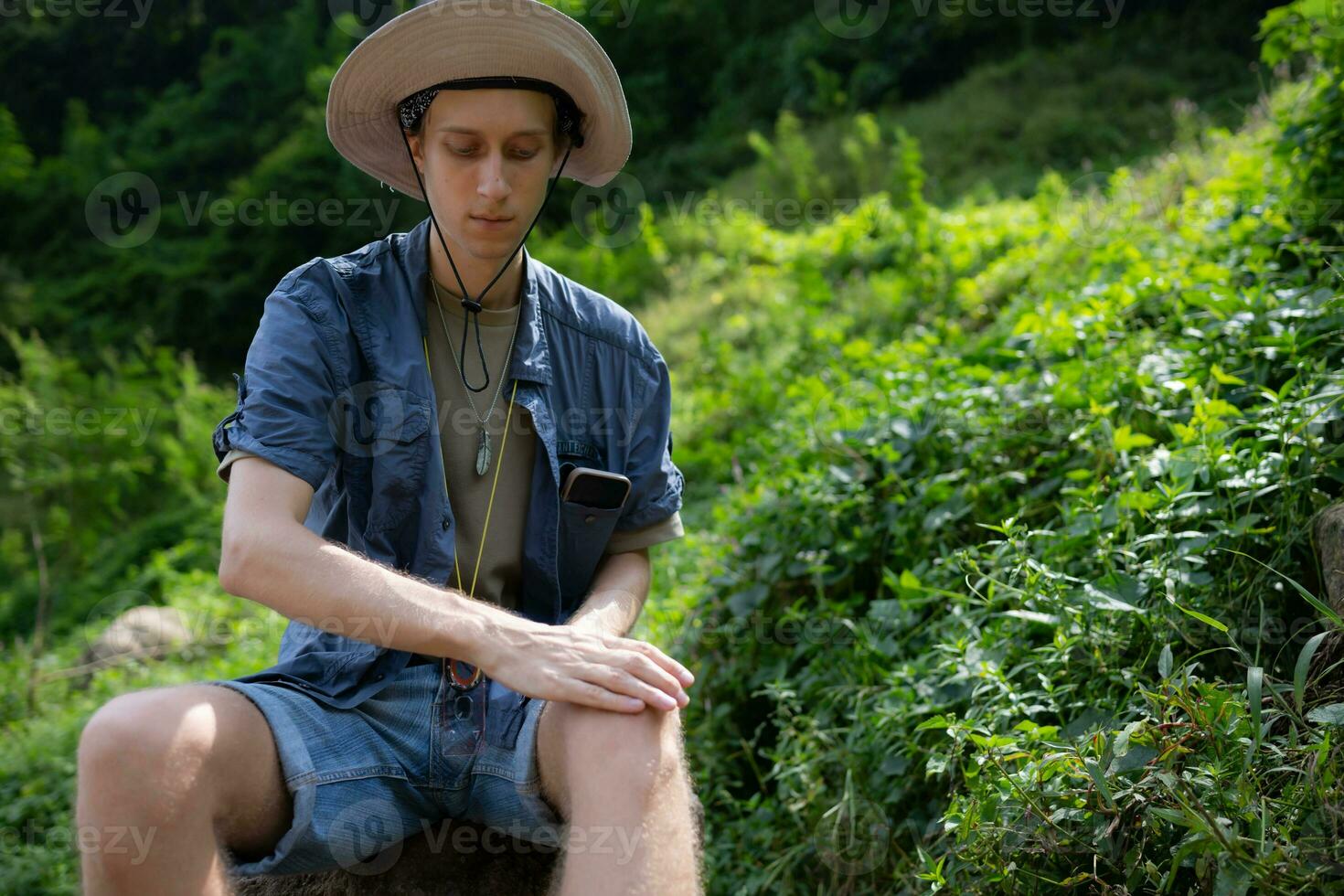 Close-up shot of young man applying painkiller to massage his knee, Pain from hiking photo