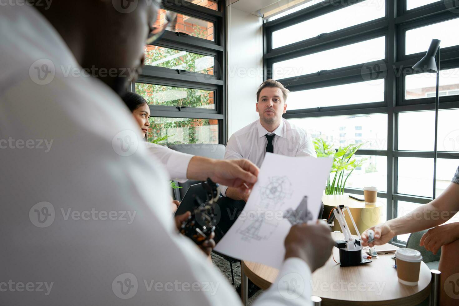 Group of diverse business people working together in the office, Brainstorming about the hand robot model to be used for production work photo