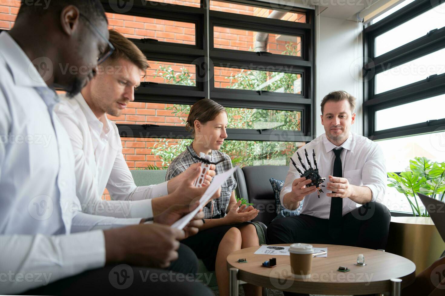 Group of diverse business people working together in the office, Brainstorming about the hand robot model to be used for production work photo