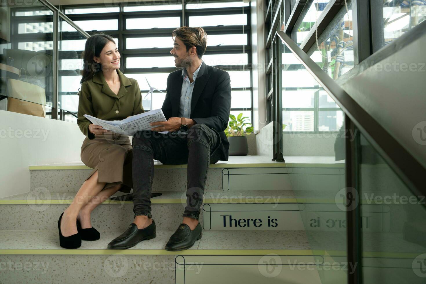 ambos de persona de negocios sentado en escalera en oficina hablar y intercambiar ideas en utilizando natural energía en edificios antes de entrando el reunión a presente y considerar foto