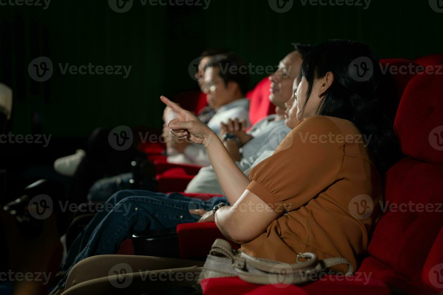 Asian mother and daughter watching movie in cinema. Family time concept. photo