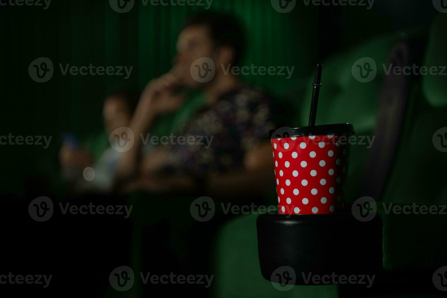 Cinema concept. People watching movie at cinema drink water and eating popcorn photo