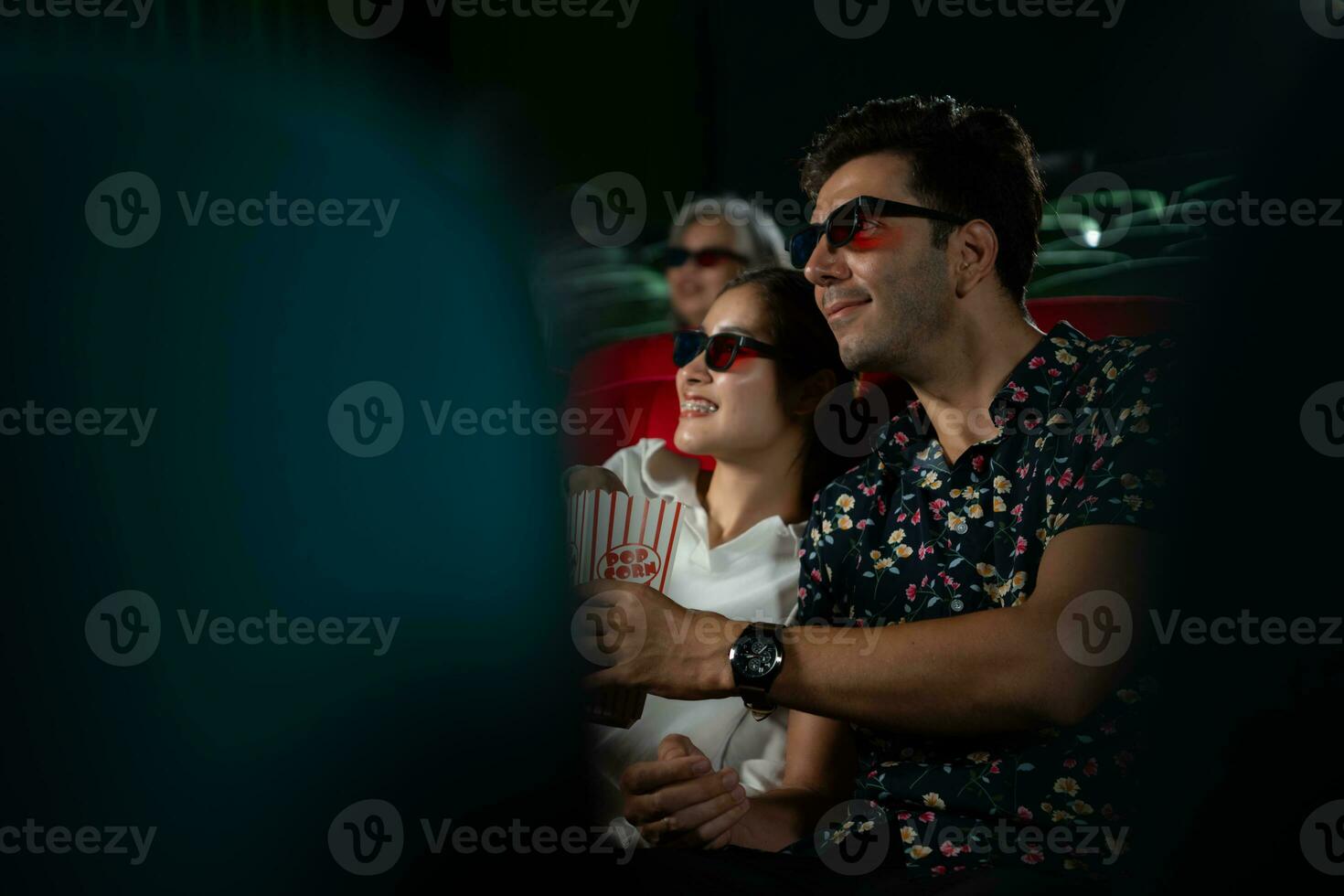 en un cine, un joven Pareja par vistiendo 3d lentes relojes películas y come Palomitas. foto