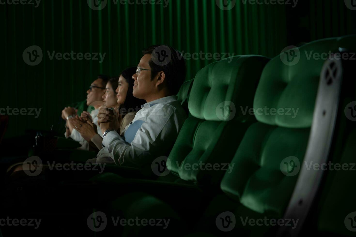 Family members of an Asian senior woman clap their hands for the movies she watches with the impression photo