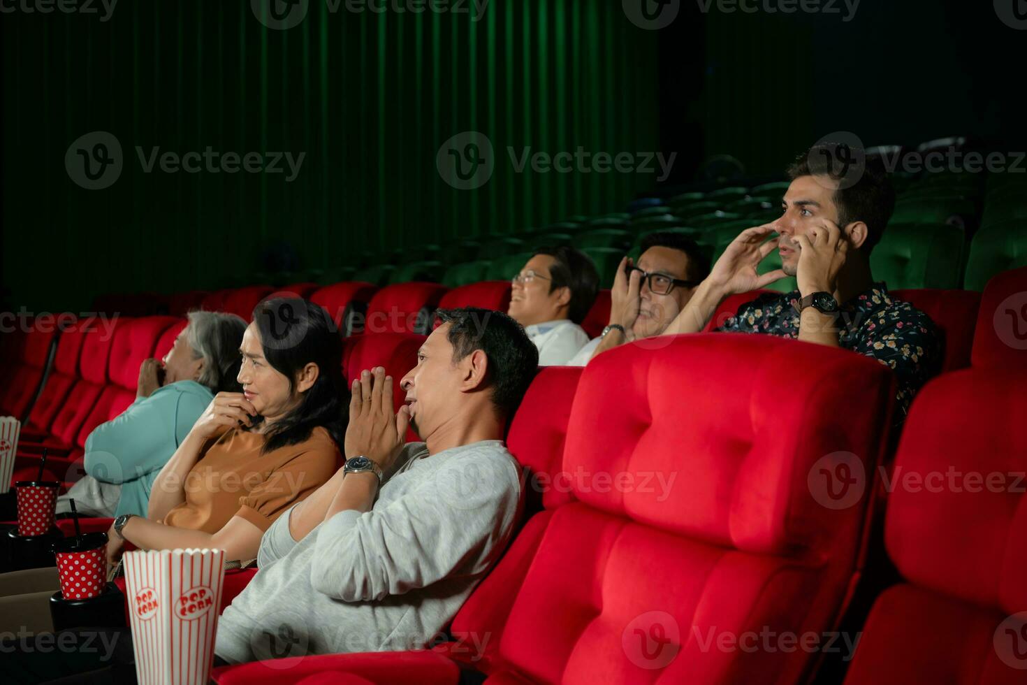 When watching scary ghost movies in theaters, moviegoers appear terrified. photo