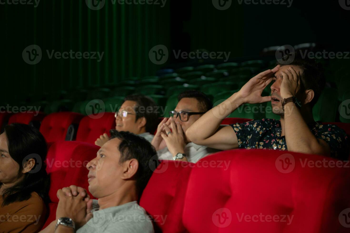 When watching scary ghost movies in theaters, moviegoers appear terrified. photo