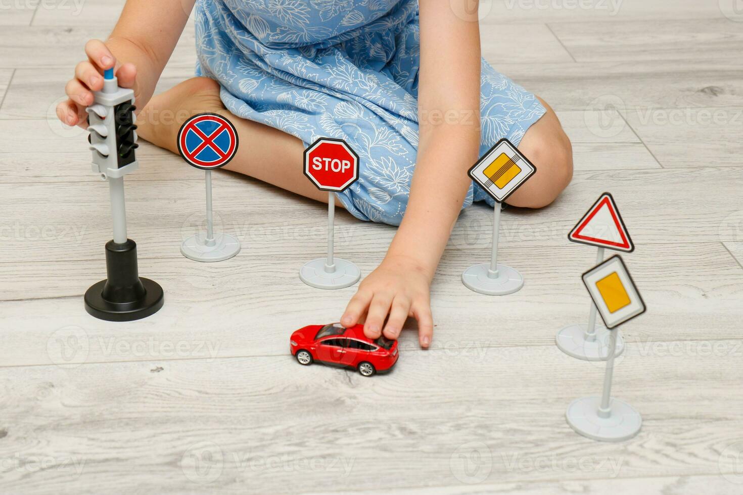 cute little girl playing at home on the floor with a road signs and traffic lights photo