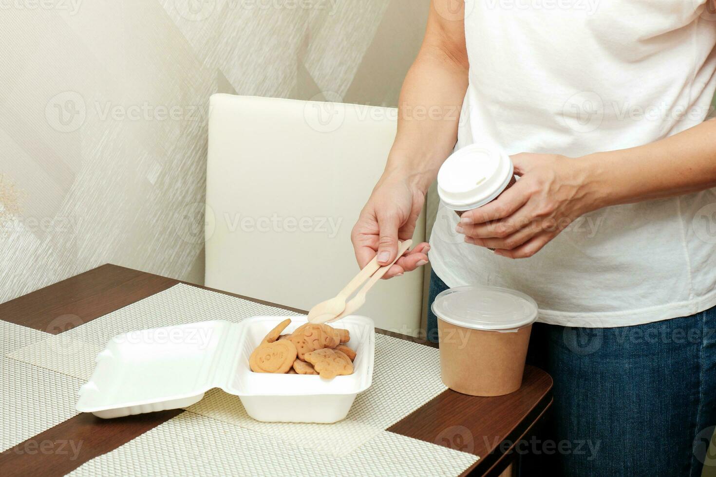 woman stacks food for child in lunchbox and container photo