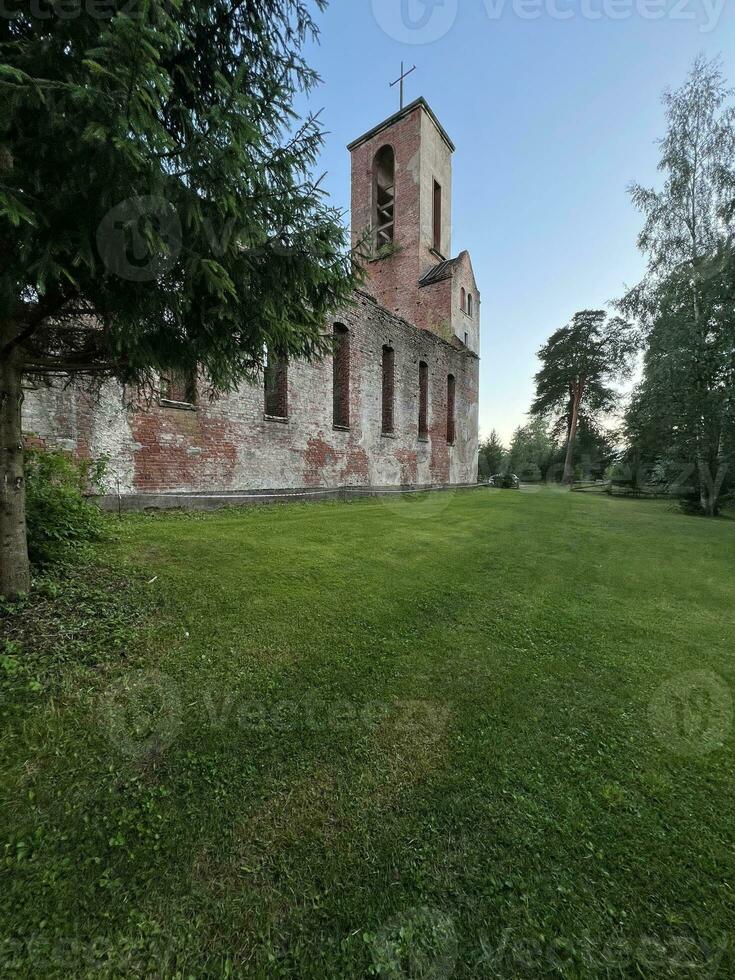 green lawn near the walls of an old abandoned church, summer landscape photo