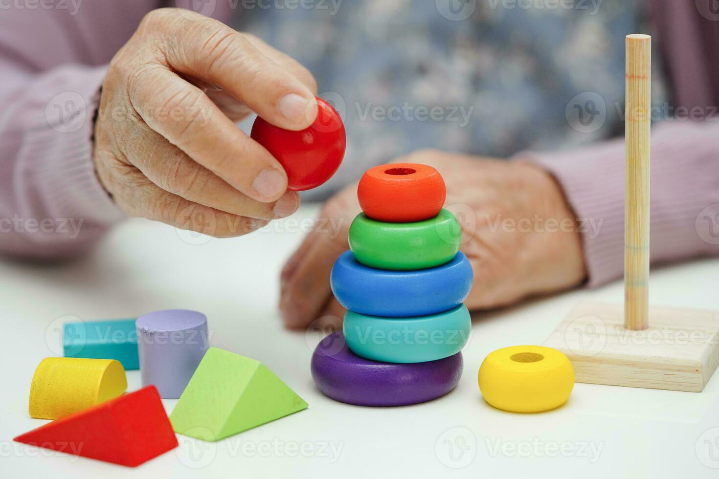 Bangkok, Thailand - May 15, 2022 Asian elderly woman playing Rubik cube game to practice brain training for help dementia prevention and Alzheimer disease. photo