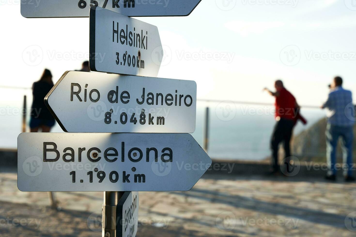 firmar indicando el dirección y distancias en kilómetros a algunos importante ciudades en el mundo para ejemplo Barcelona foto