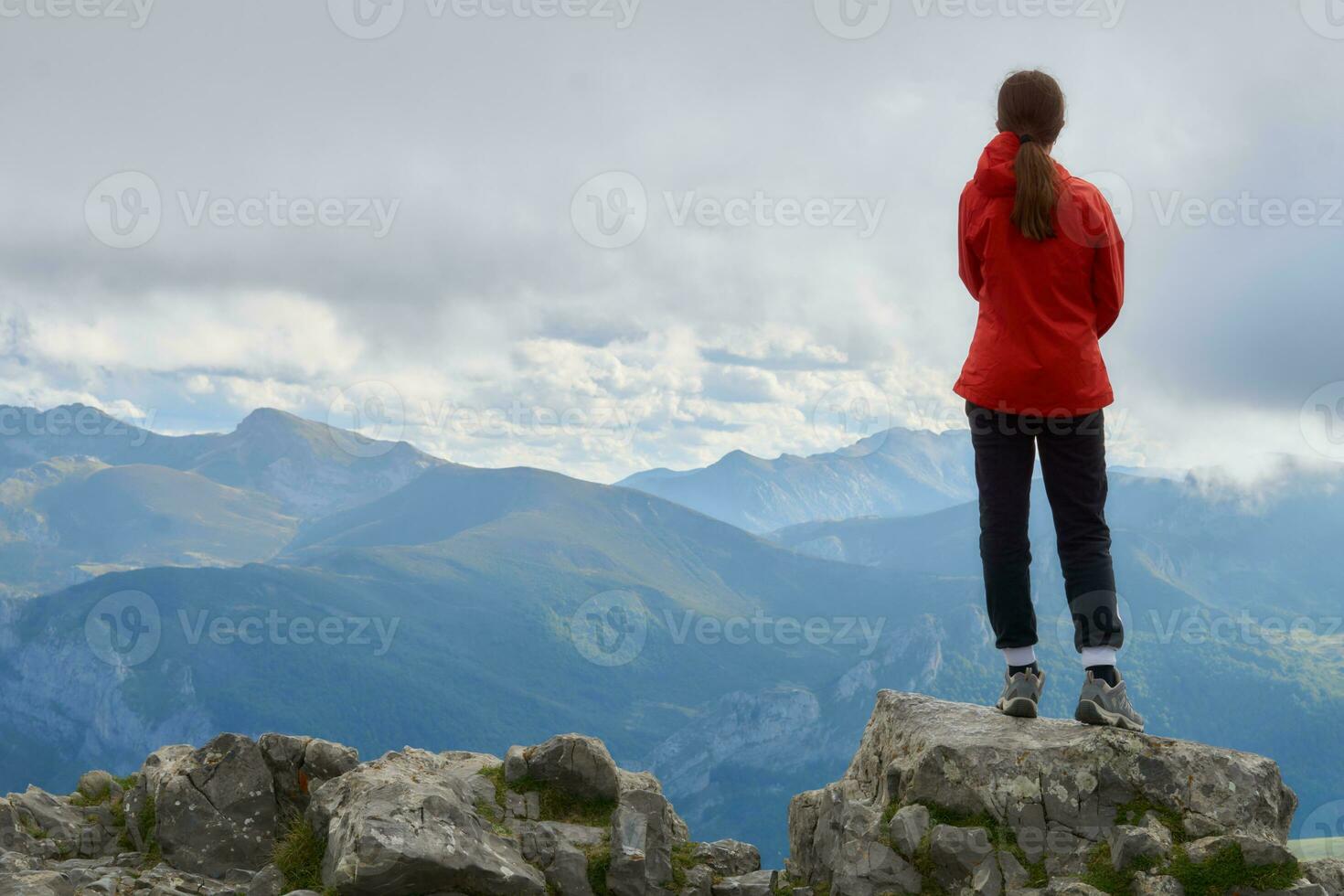 Adventurous 13-Year-Old Girl Gazing at European Peaks from Hilltop as Storm Approaches photo