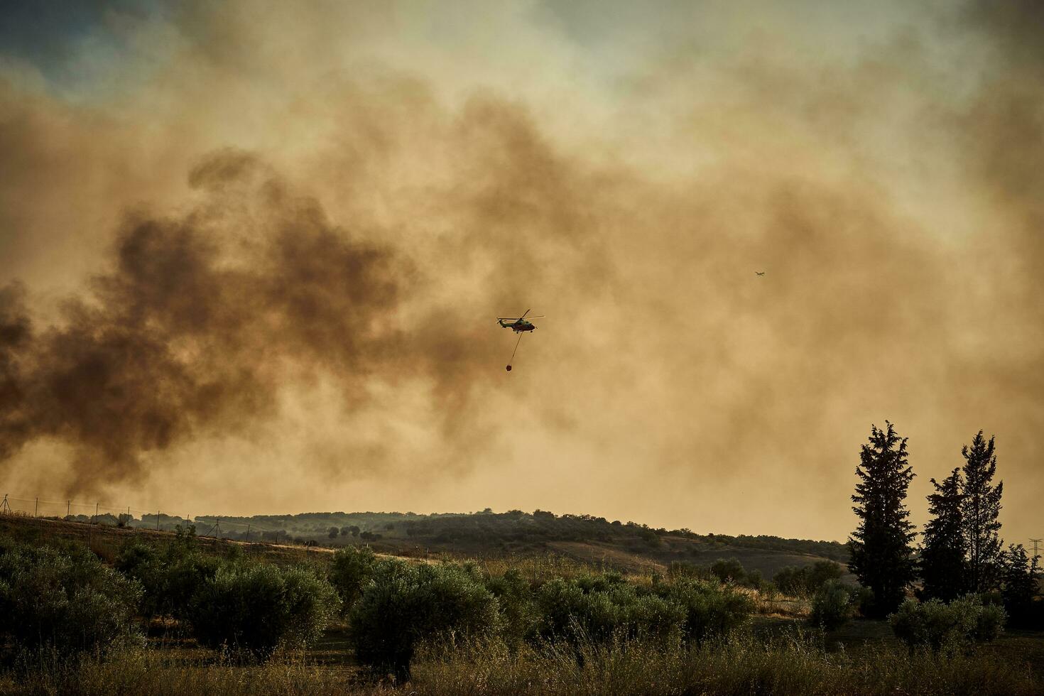helicopter, Firefighters, prepares the trajectory to pour water on the forest fire. 2 photo