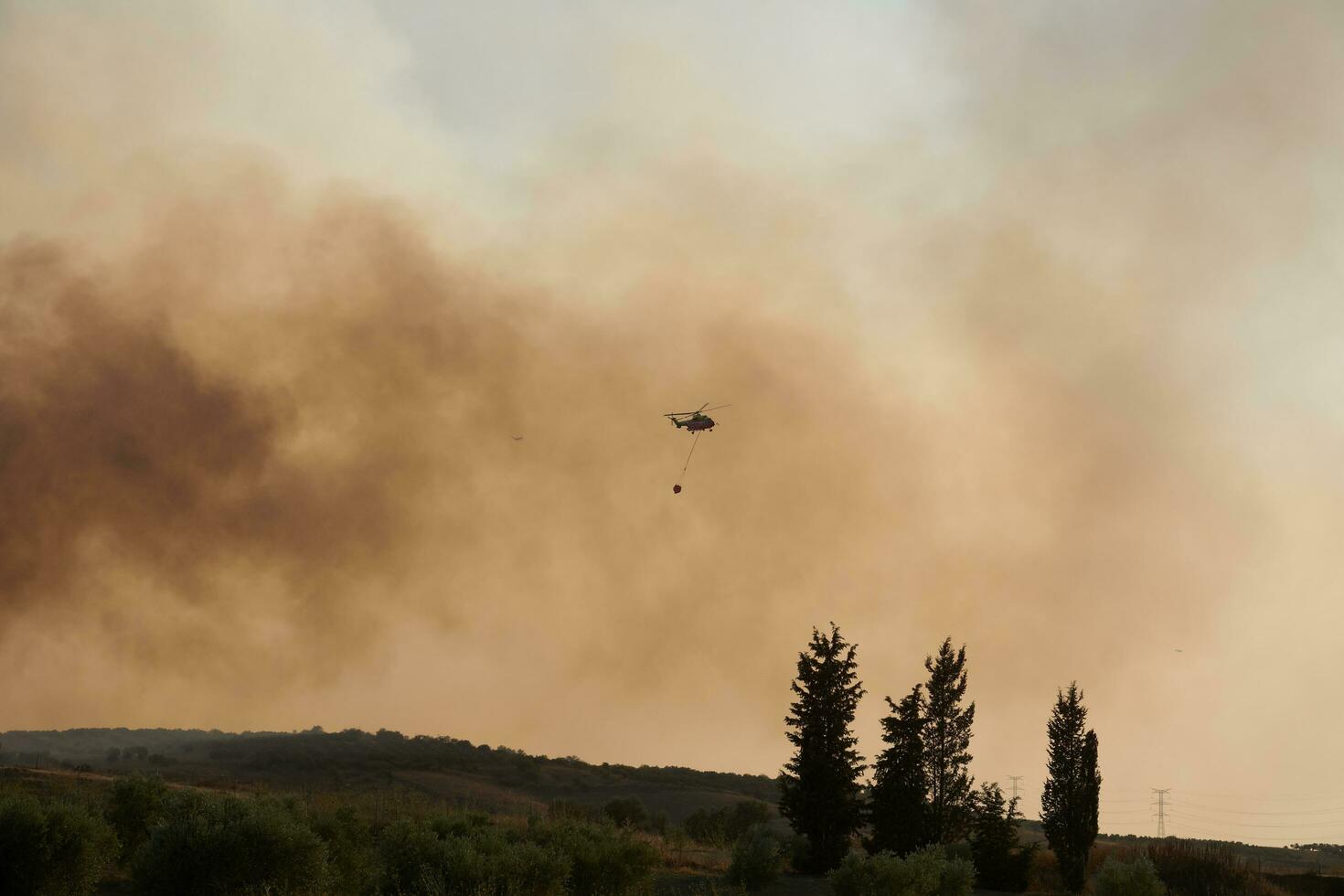 helicopter, Firefighters, prepares the trajectory to pour water on the forest fire. 3 photo