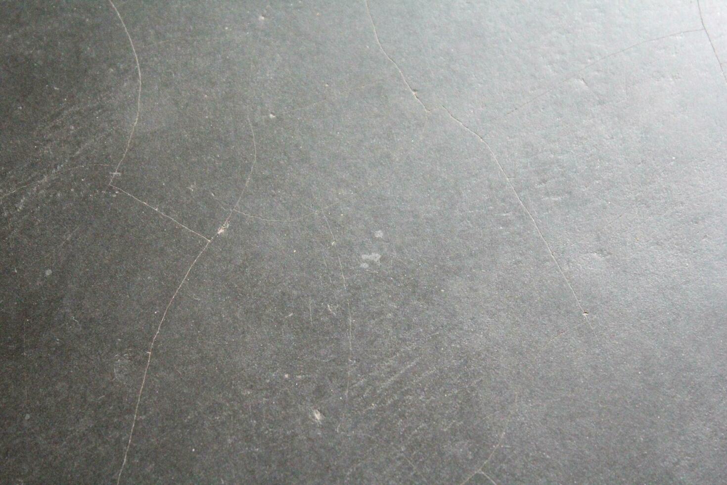 Dark cracked floor surface, shiny deep dark background, grungy floor background photo