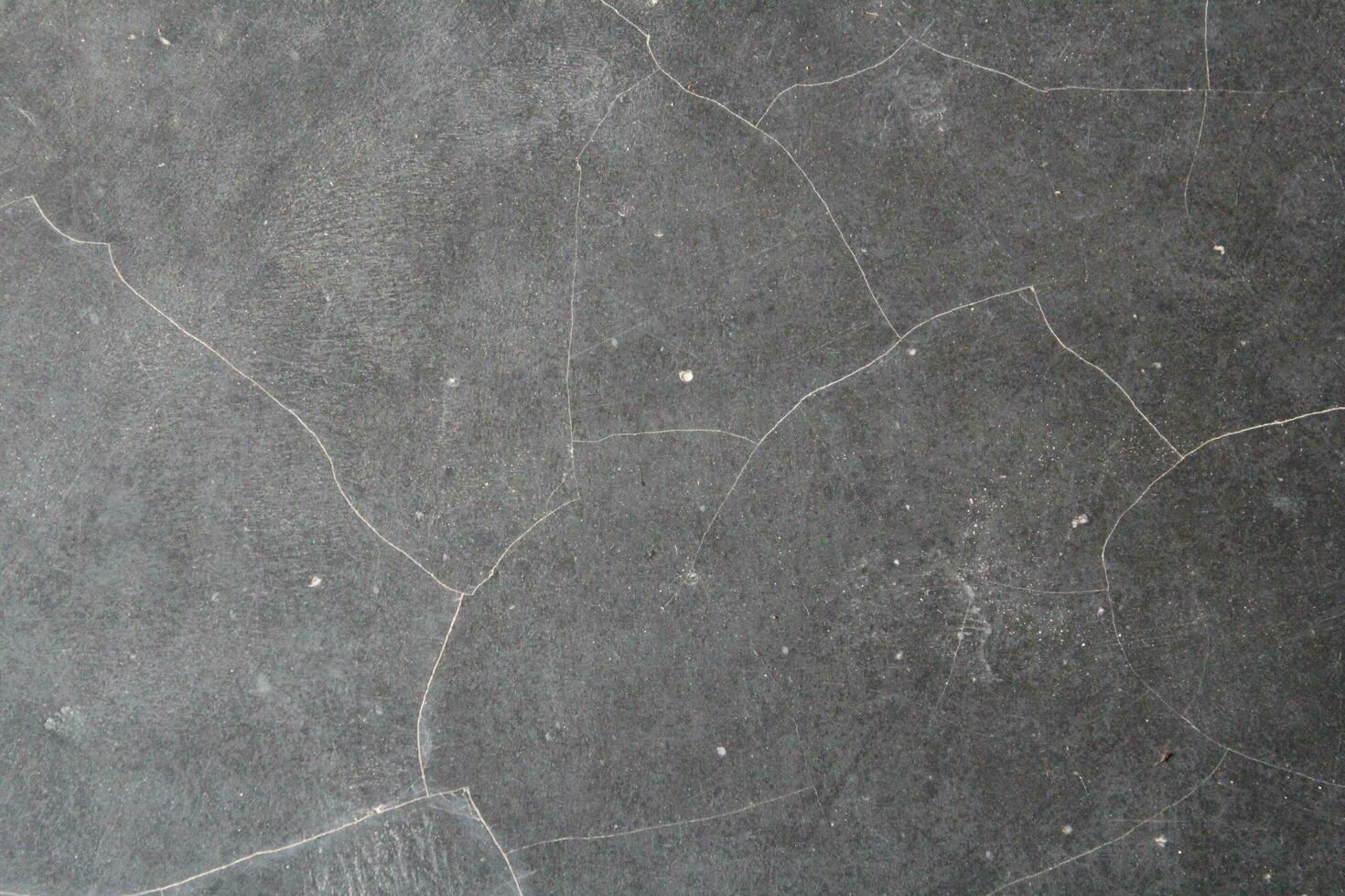Dark cracked floor surface, shiny deep dark background, grungy floor background photo