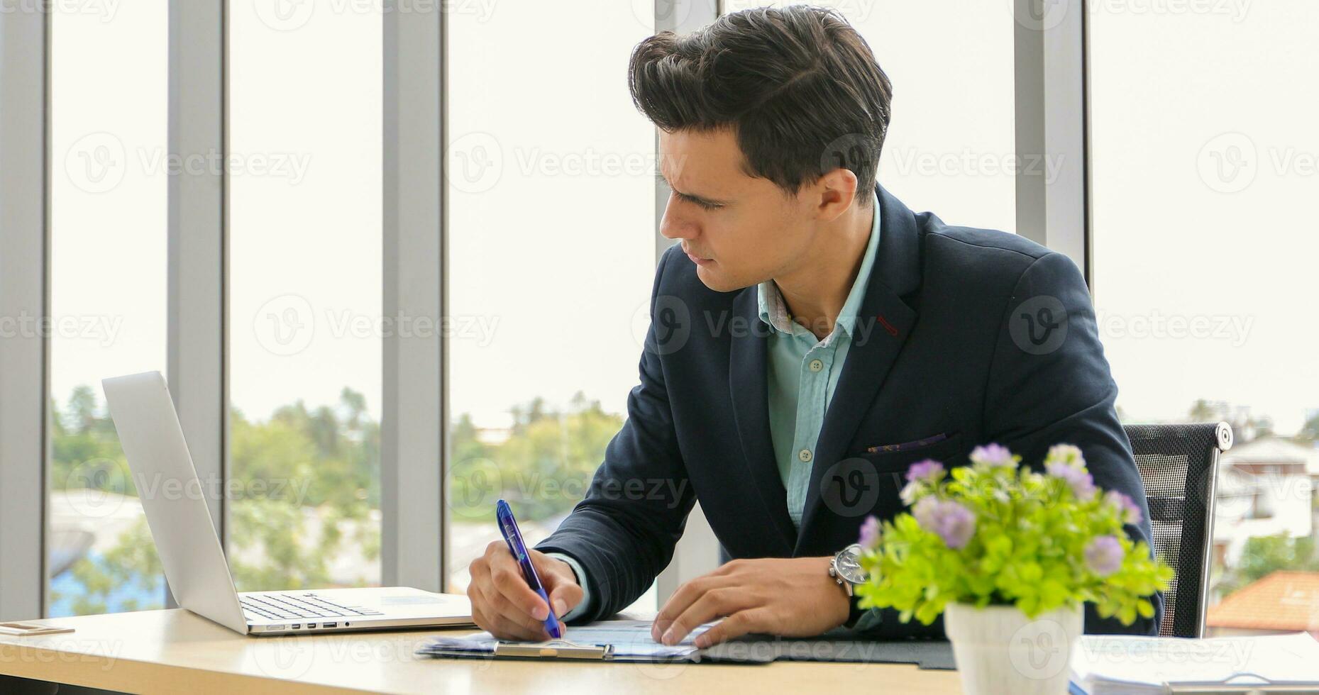 businessman using laptop and contemplating while working at his desk in the office. photo