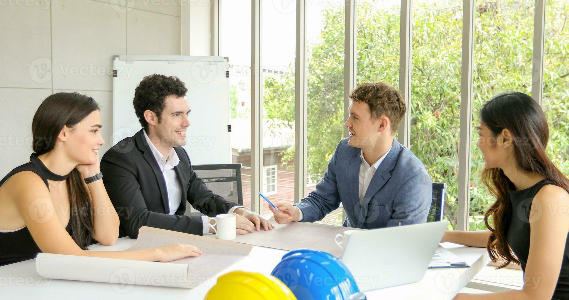 Diverse group of engineers, technicians, and specialists on meeting analyze technical drafts and hardhat presenting blueprint to business people in office photo